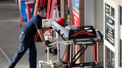 EMT wheeling someone in a stretcher into the emergency department